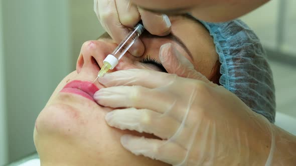 The Cosmetologist Makes Injections on the Client's Face in the Lip Area