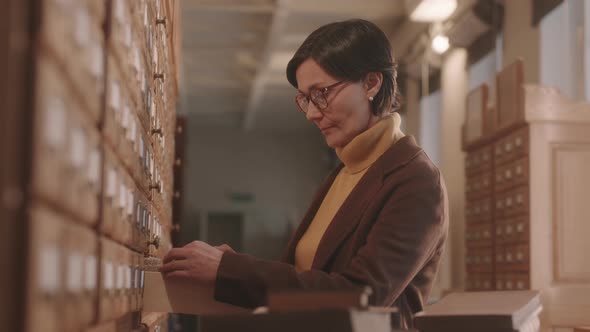 Female Librarian Sorting Library Card Catalogue