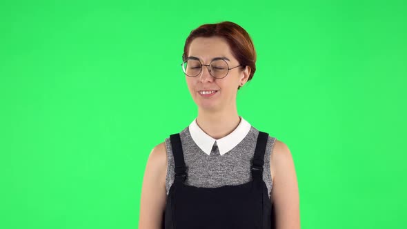 Portrait of Funny Girl in Round Glasses Is Winking and Flirting, Green Screen