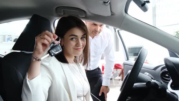 Happy Brunette Woman Showing Car Key to Camera After Buying New Car
