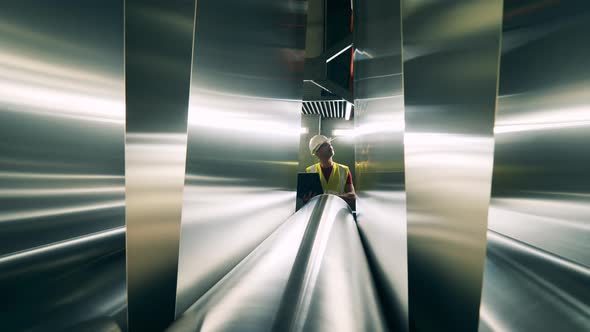 Industrial Factory Specialist Is Watching Metal Panels Rolling Through the Conveyor