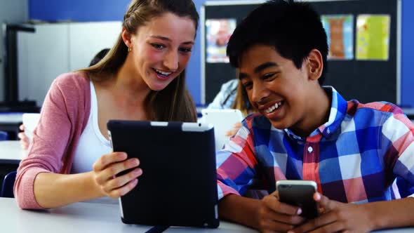 Students using digital tablet and mobile phone in classroom