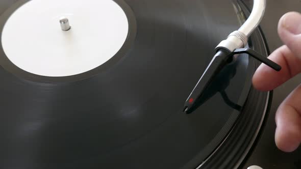 Close up footage of a turning vinyl and a spherical needle on it