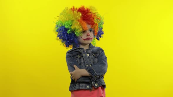 Little Child Girl Clown in Colorful Wig Making Silly Faces. Fool Around, Smiling, Dancing. Halloween