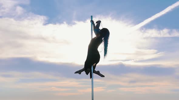 Pole Dance on Nature - Woman with Blue Braids in Black Dress Gracefully Dancing on the Background of
