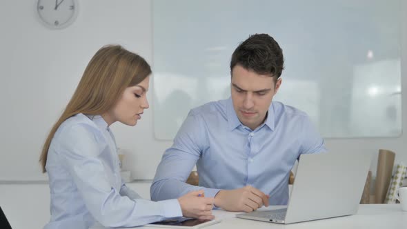 Two Young Business Colleagues Working on Laptop