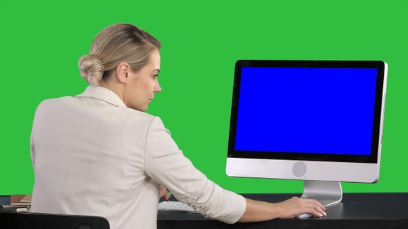 Business woman working on her computer on a Green Screen