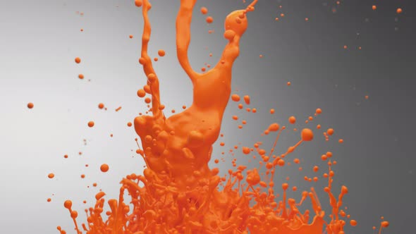 Orange paint bouncing and making splash. Slow Motion.