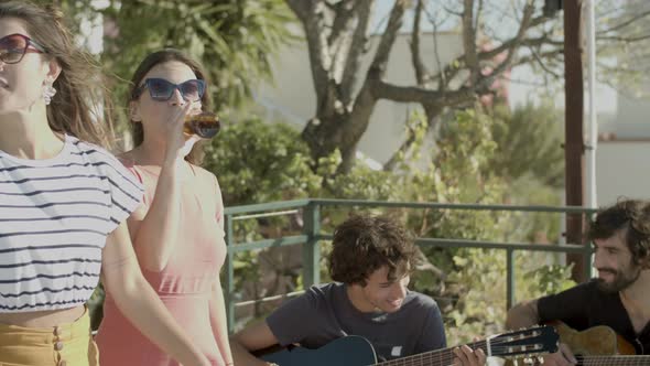 Handsome Men Sitting and Playing Guitar During Rooftop Party