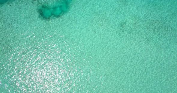 Aerial drone view of a woman floating and swimming on a tropical island