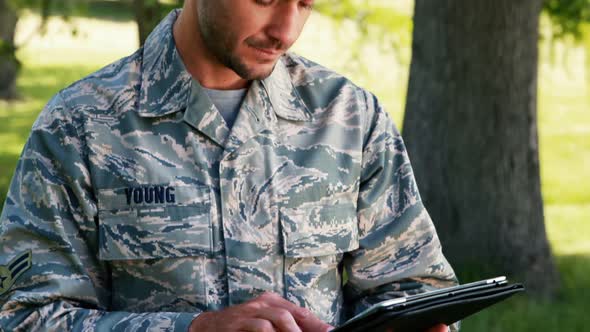 Soldier using digital tablet in park