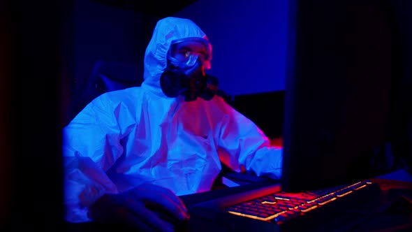 A Man in Medical Protective Suit and Black Respirator Playing Game in Gaming Club