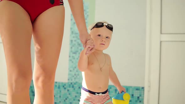 Young Mother and Her Cute Little Blonde Child Walking Near Swimming Pool