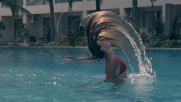 Graceful Girl Shakes Long Hair in Pool at Resort Slow Motion