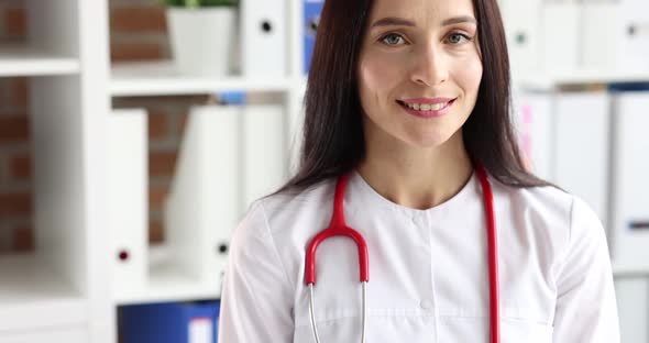 Portrait of Smiling Female Doctor in White Coat with Stethoscope Closeup