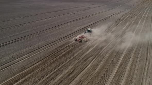 Agricultural Green Big Tractor in the Field Plowing