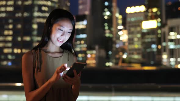 Woman using smart phone in Hong Kong at night 