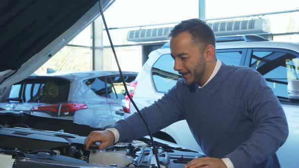 A Cheerful Man Opened the Hood of the Car and Studied What Is Inside