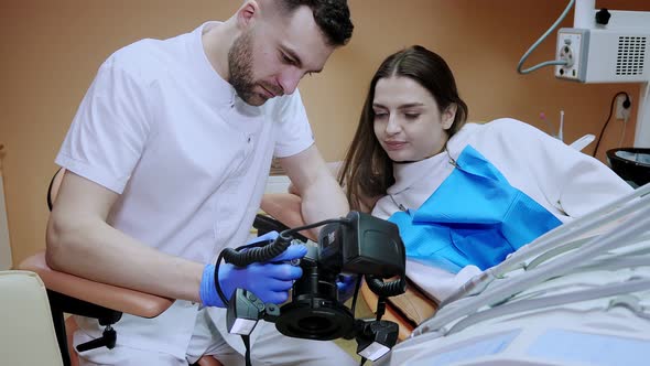 The dentist shows the patient a picture of the result of treatment. Satisfied patient