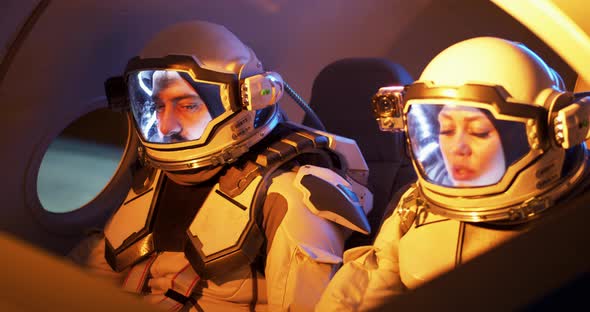 Male and Female Astronauts Navigating Spaceship