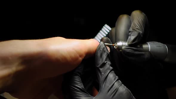 Closeup View of Manicure Master Polishing Male Client Nails By Electric Drill
