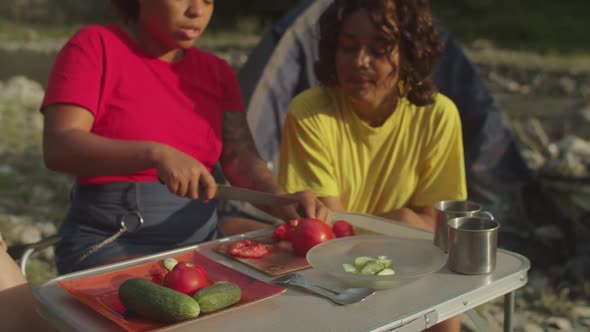 Lovely Multiethnic Female Tourists Preparing Camping Meal at Campsite on Mountain Hiking