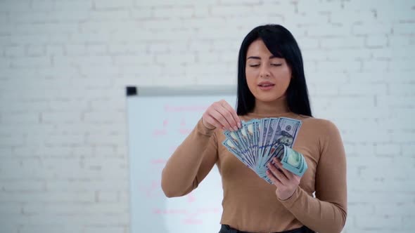 Woman holding money banknotes. Portrait of a cheerful young woman holding money banknotes