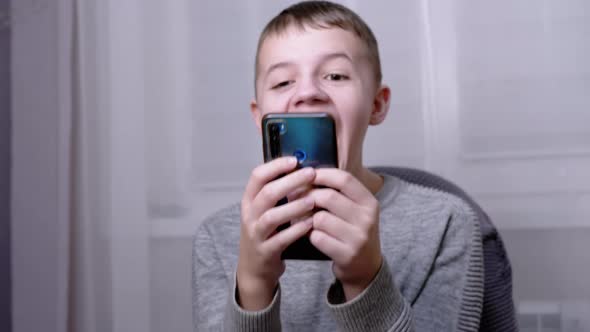 Nervously Laughing Emotional Child Poked His Finger at the Smartphone Screen