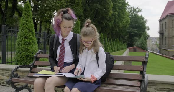 Two Schoolgirls Sitting on Bench, Primary and High School Student