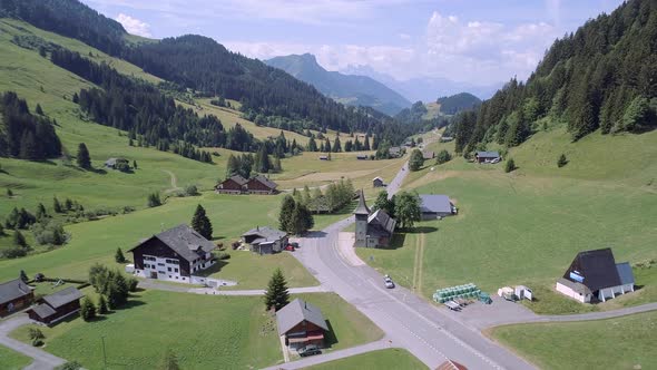 Aerial View of a Valley in Switzerland with Chalets and a Mountainous Landscape