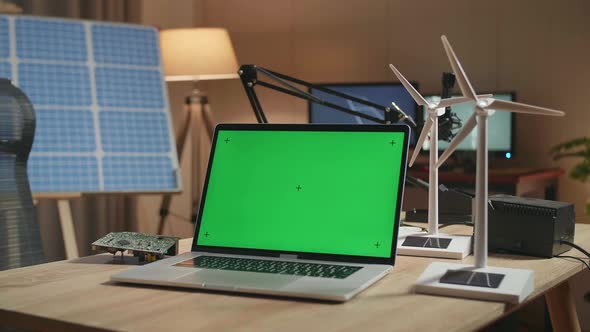 Green Screen Laptop And Wind Turbine On The Table Next To The Solar Cell At The Office