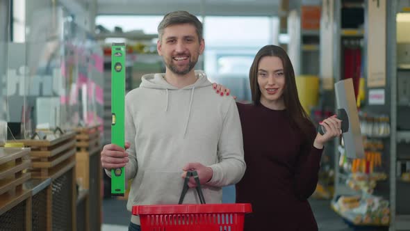 Middle Shot of Smiling Confident Caucasian Couple Posing with Repair Appliances in Hardware Store