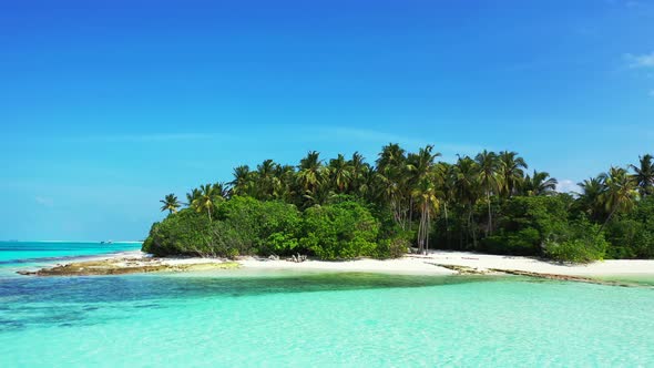 Tropical fly over tourism shot of a sunshine white sandy paradise beach and aqua blue water backgrou