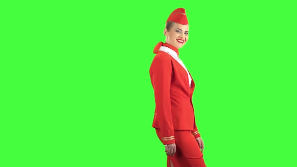 Stewardess Steps Forward and Looks in Front of Her. Green Screen. Side View