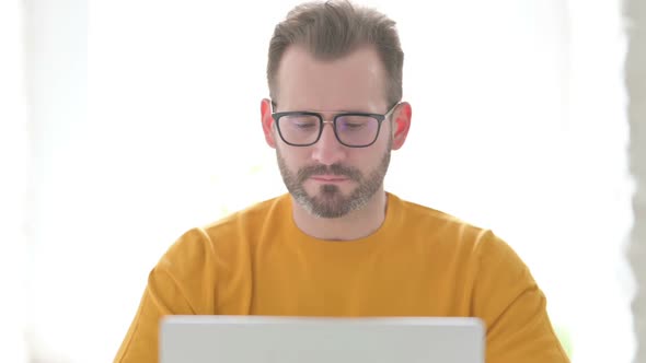 Portrait of Man with Laptop Shaking Head As No Sign