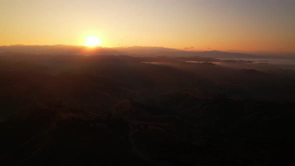 4K Aerial view from drone over mountains fog. Golden scenery at sunrise