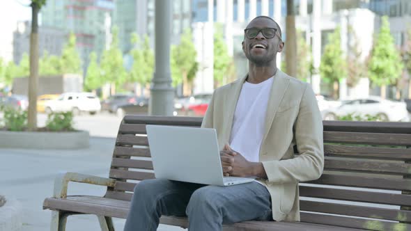 Agree African Man in Acceptance While Using Laptop Sitting Outdoor on Bench