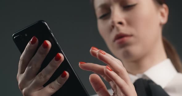 Vexed and Dissatisfied European Woman Swipes the Screen of Smartphone in a Rush Angry Office Worker