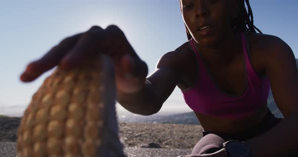 African american woman stretching her legs on the highway