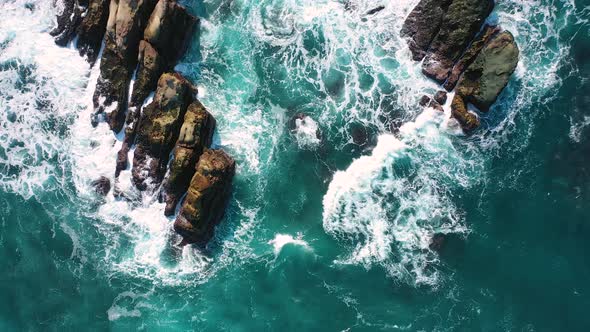 ocean blue waves break on high cliff of a rocky mountain. Danger sea waves on a