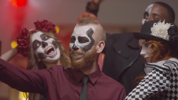 Cheerful Friends in Halloween Costumes Taking Selfie