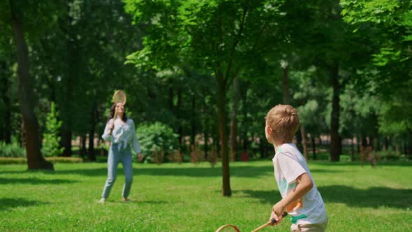 Active Boy Playing Badminton with Mother Back View