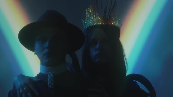 Portrait of Gothic Queen and Priest in Dark Studio