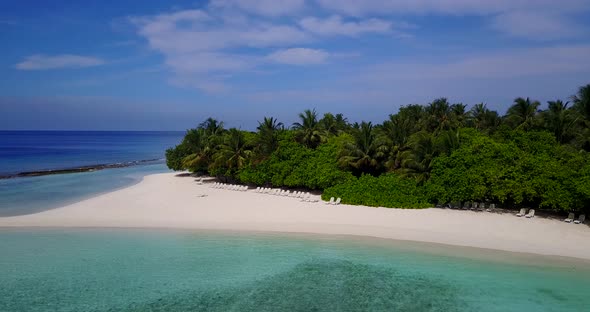 Beautiful fly over clean view of a sunshine white sandy paradise beach and aqua blue water backgroun