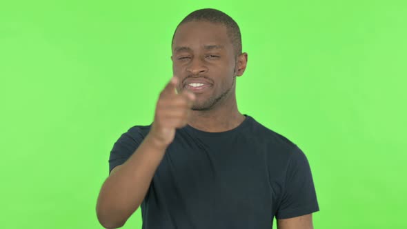 Happy Young African Man Pointing at the Camera on Green Background