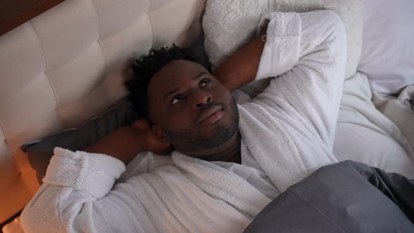 High Angle View Portrait of Smiling Happy African American Man Lying in Bed Looking Away