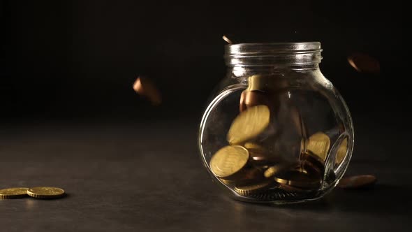 Money coin falling into glass jar , money saving concept