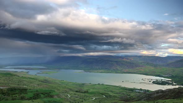 Storm Clouds and Rain Approaching to Lake Geography Surrounded by Hilly Meadows