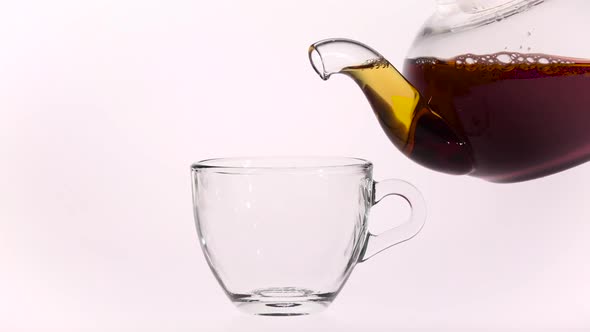 Into Transparent Cup Poured Black Hot Tea From Glass Teapot