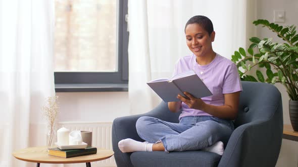 Happy African American Woman Reading Book at Home